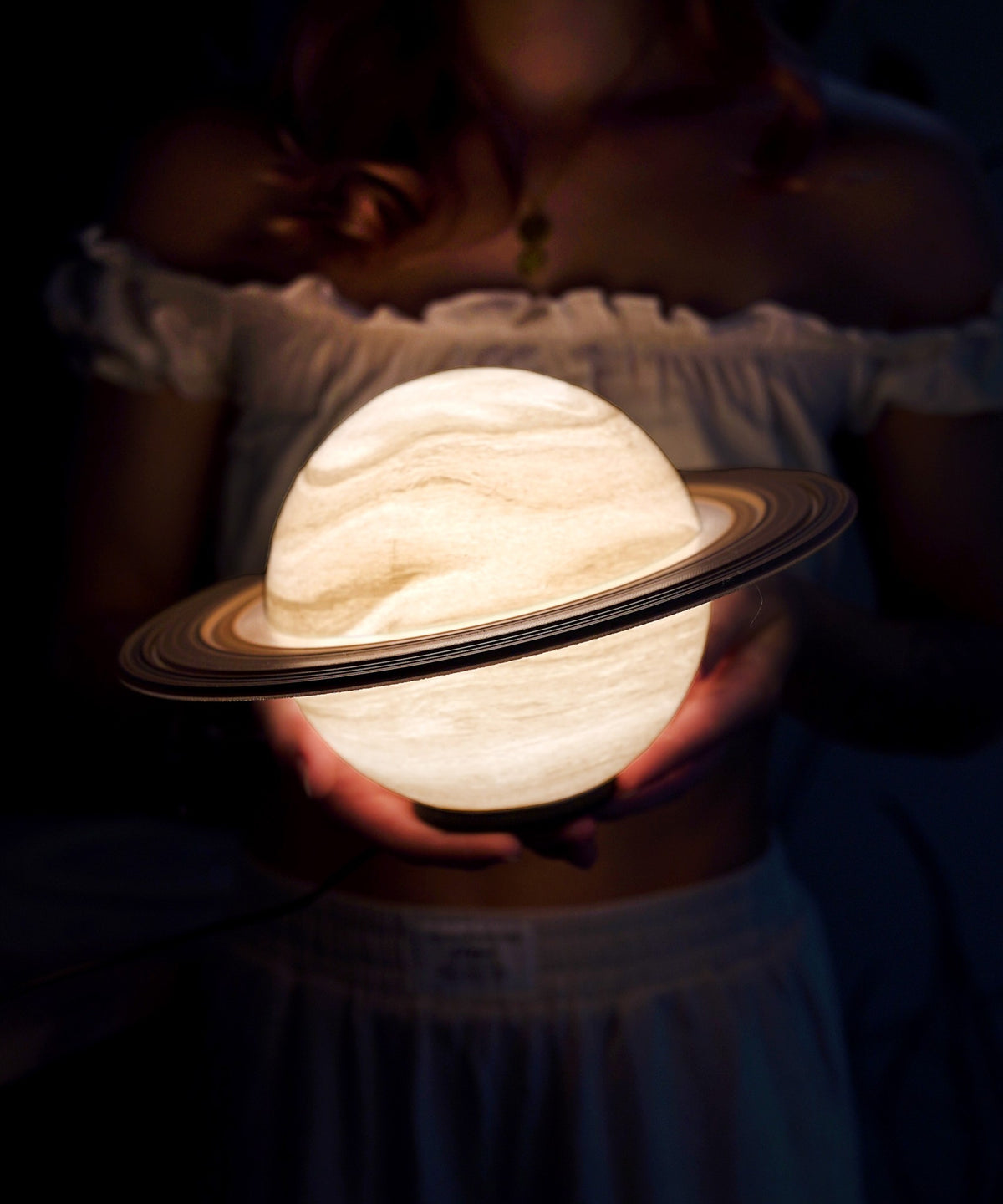 Saturn Planet Lamp — glowing globe and tilted ring held up close