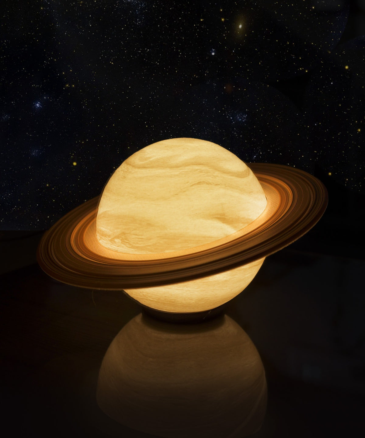 Saturn Planet Lamp — lit with a brown ring against a starry backdrop
