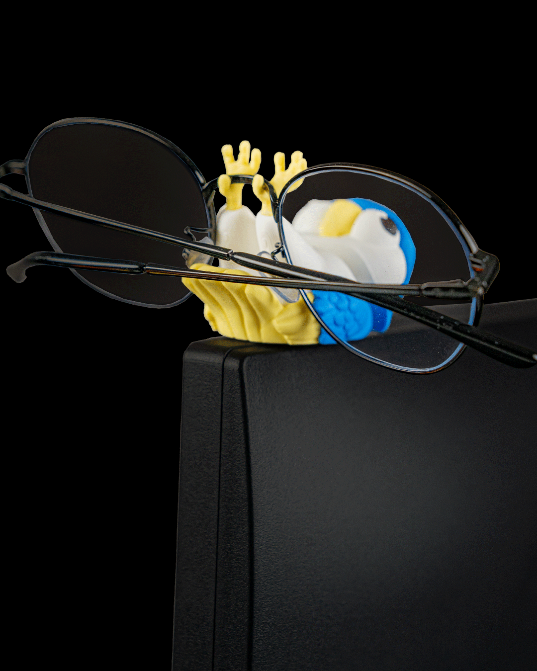 Perchmate — a 3D-printed parakeet glasses holder — shown on a desk