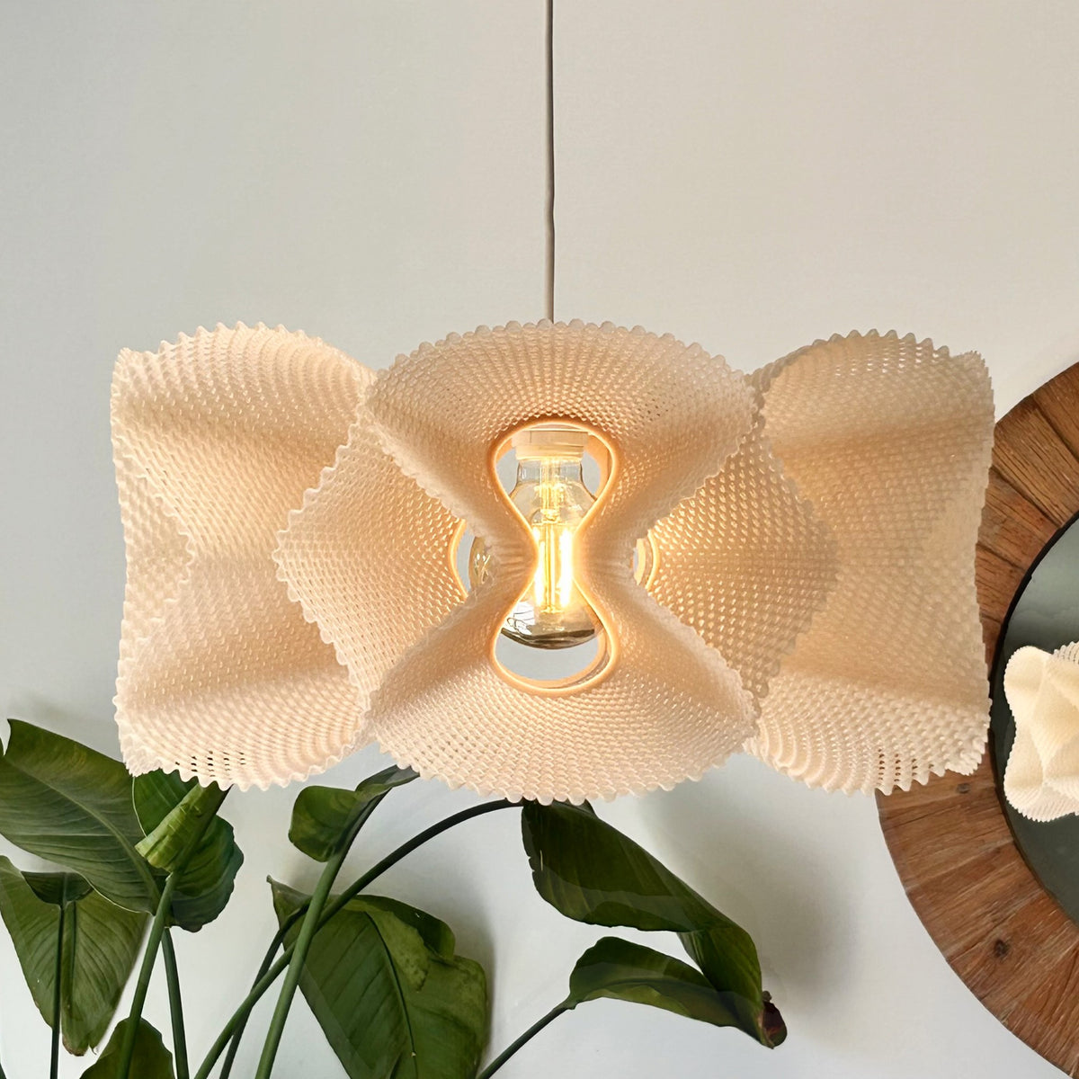 Coroa Pendant Light — lit pendant hanging from the ceiling, side view